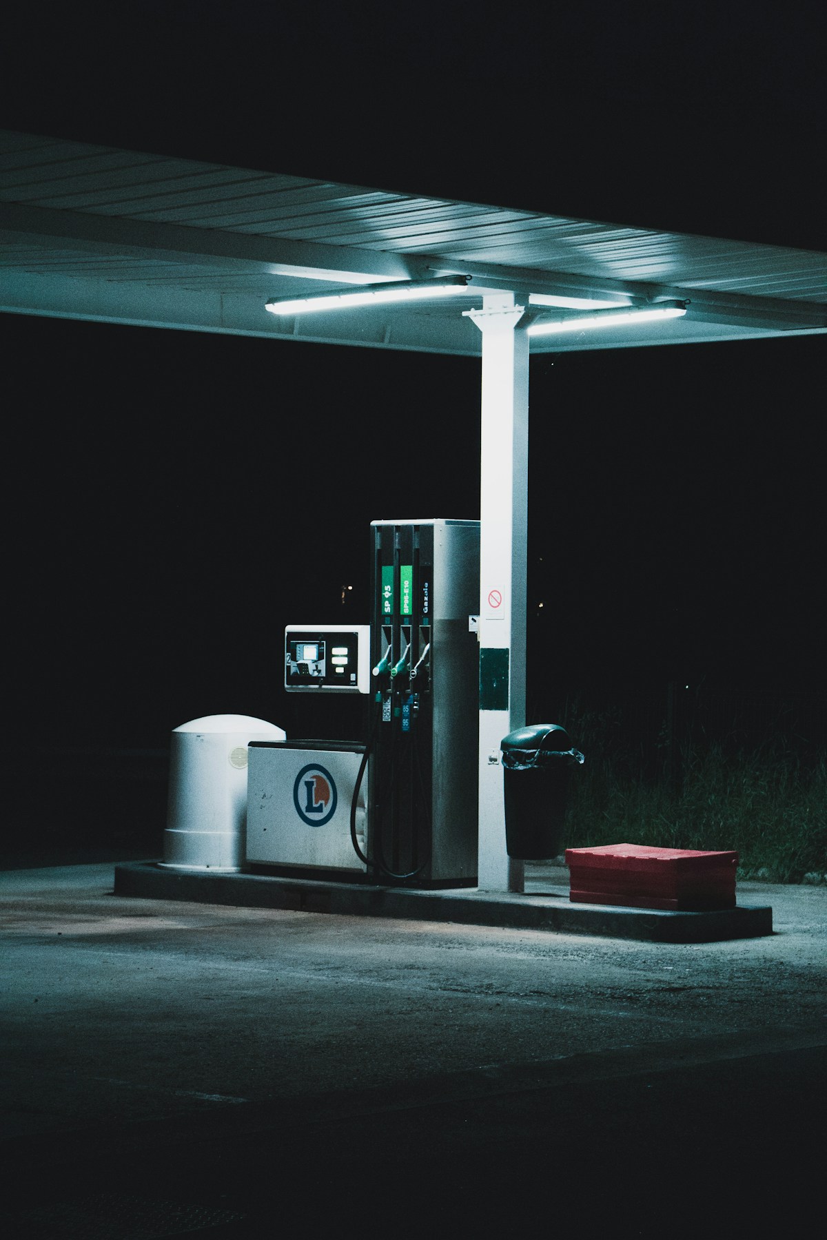A gas station fuel pump illuminated at night